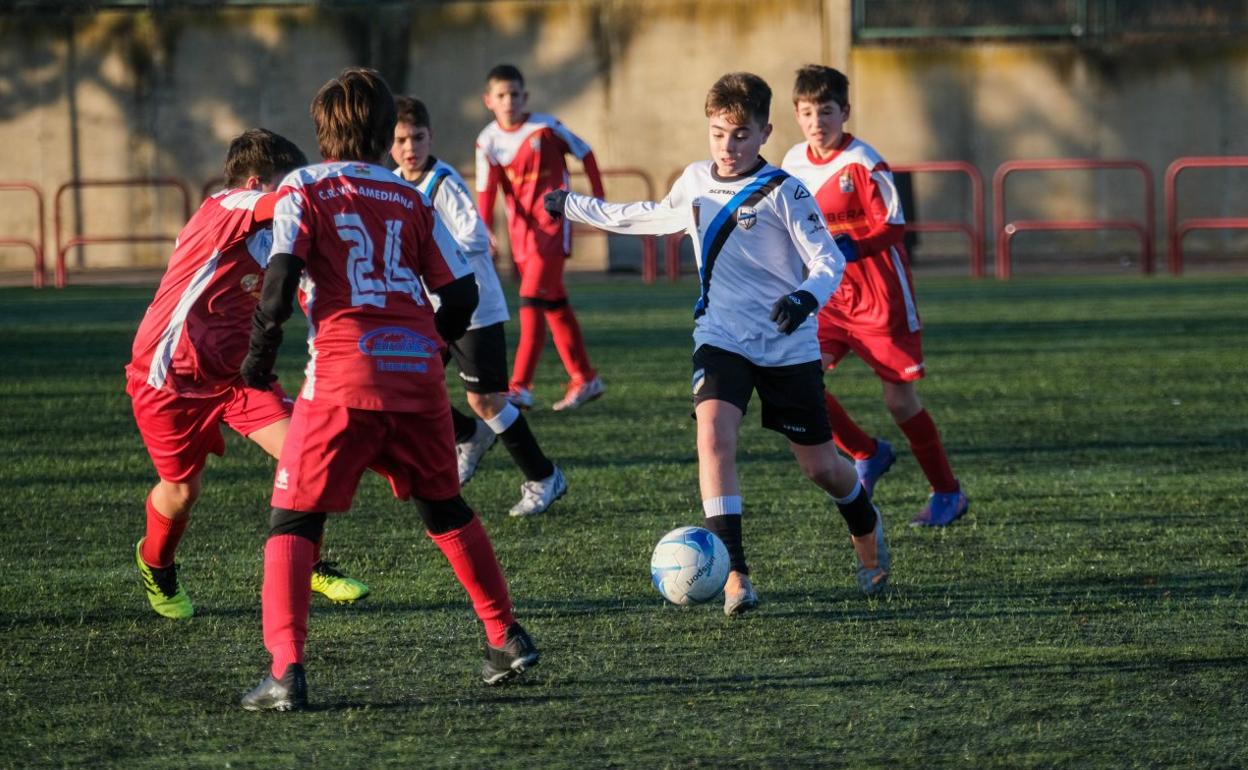 Un jugador del Valvanera conduce el balón entre varios rivales. 