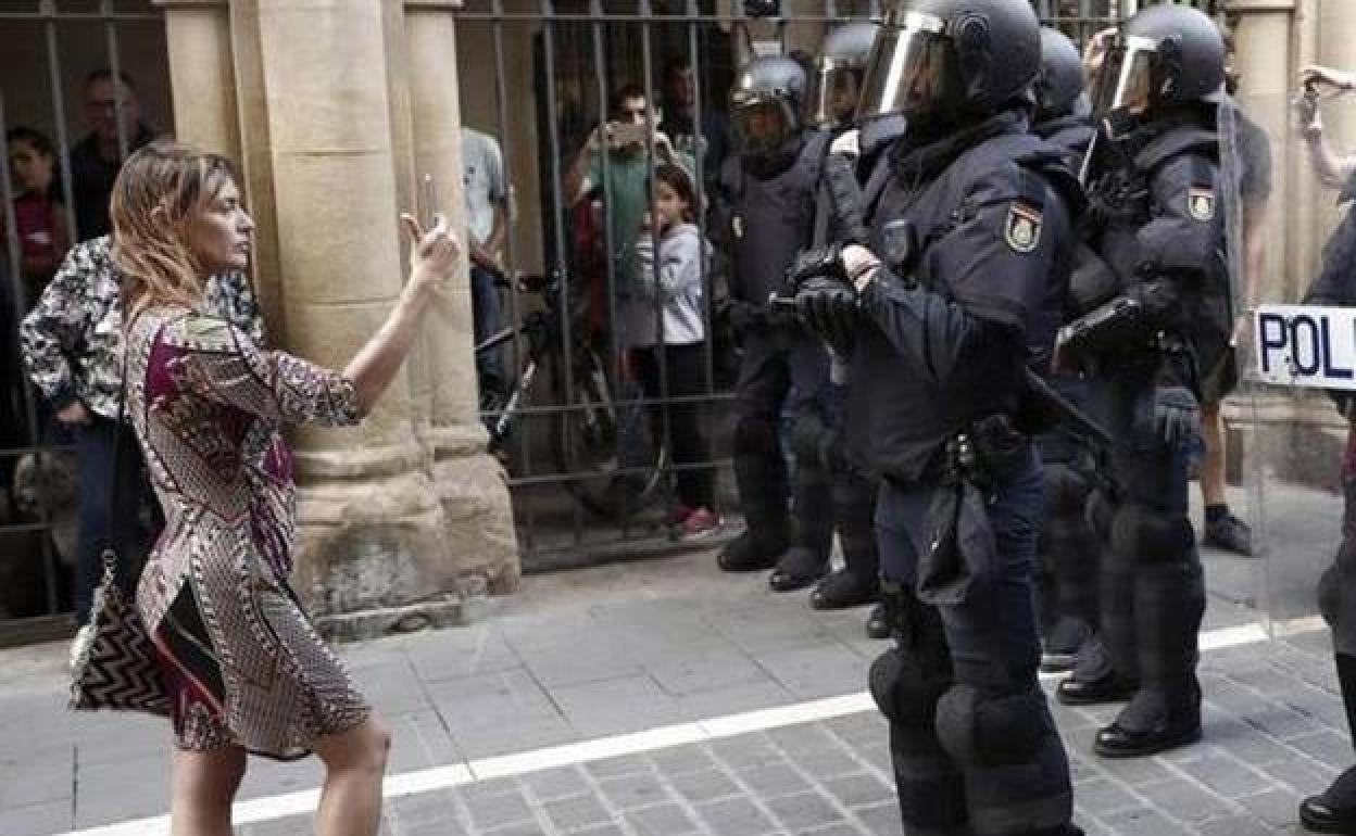 Una mujer graba a un grupo de antidisturbios durante una protesta en Pamplona.