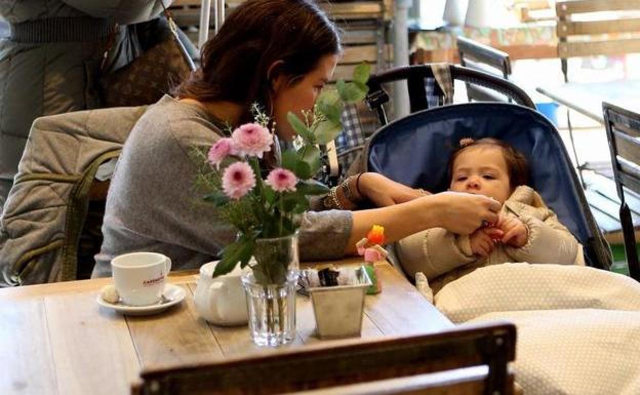 Una madre atendiendo a su bebé en una cafetería