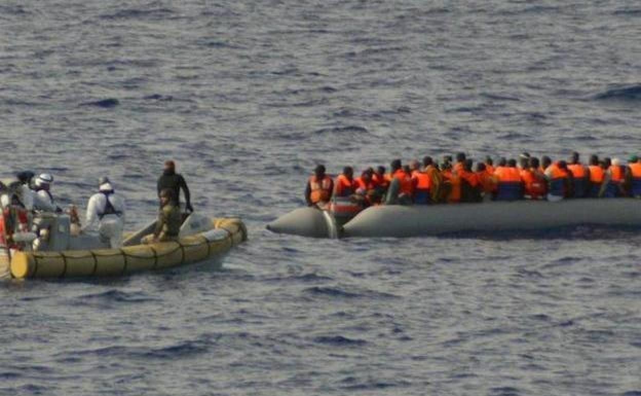 Una lancha de la Armada italiana se aproximan a un bote neumático lleno de inmigrantes cerca de la costa de Lampedusa