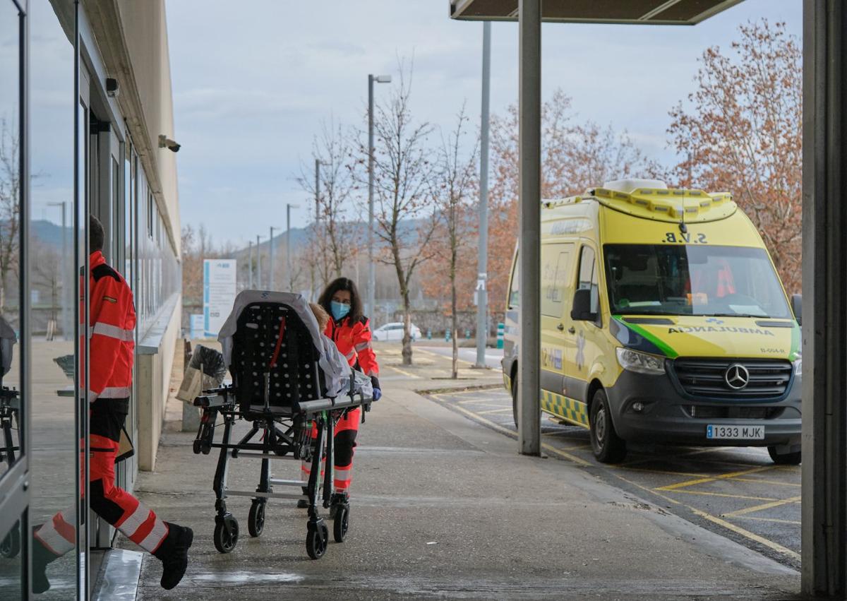 Imagen secundaria 1 - A la izquierda un enfermo entra en camilla desde la ambulancia al Hospital San Pedro. A la derecha un paciente en el pasillo en el vestíbulo de acceso a Urgencias. 