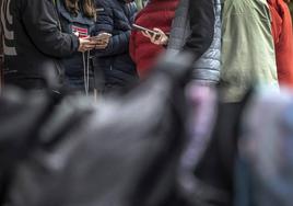 Un grupo de jóvenes utilizan sus teléfonos móviles.