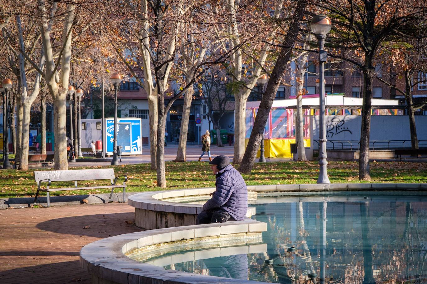 Un hombre abrigado, en un parque logroñés.