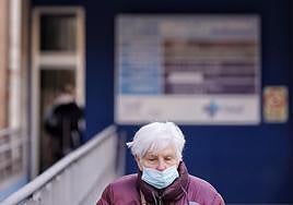 Una mujer se protege con una mascarilla en un centro de salud.