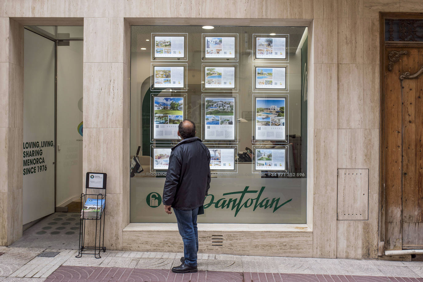 Un hombre mira el cartel de una inmobiliaria en Baleares.