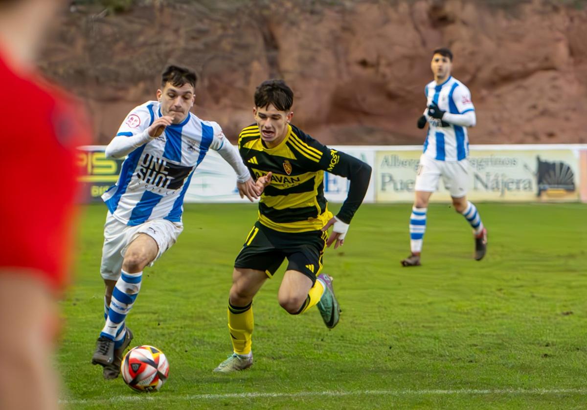 Miguel Pérez en la carrera para llevarse el balón ante el D. Aragón.