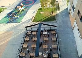 Terraza de un bar con veladores y cerramiento en la plaza Entre Ríos de Lardero.