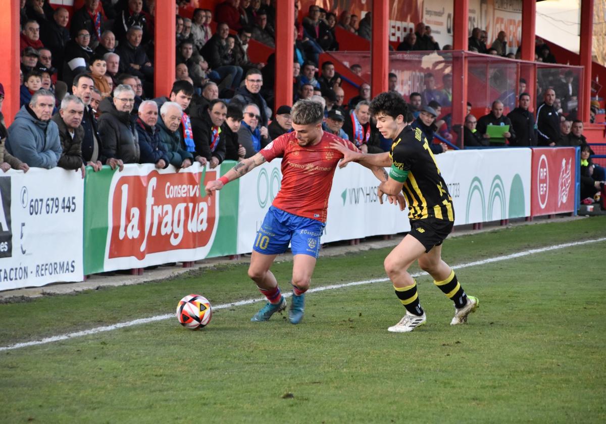 Julen Ekiza, un referente rojillo en ataque, presionado por Oier López del Barakaldo.