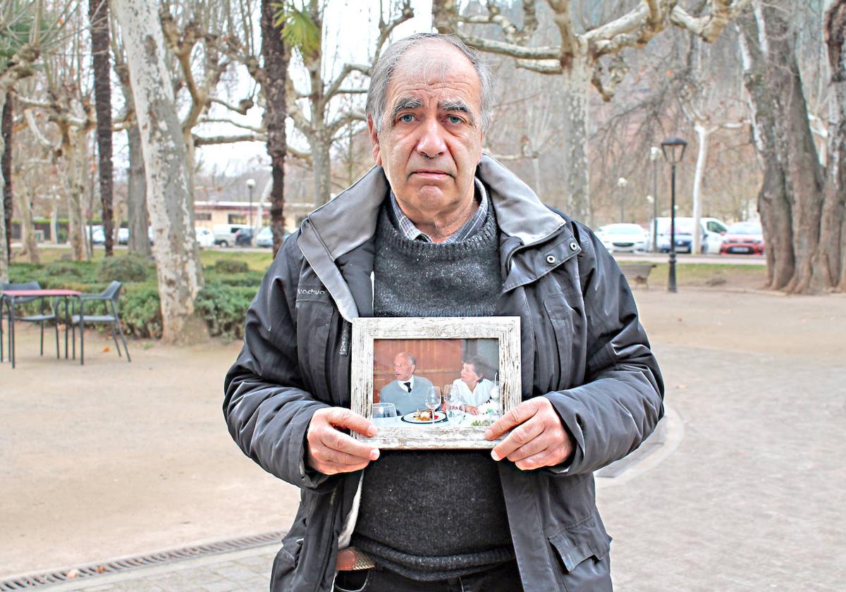 Antonio, el único hijo del matrimonio, posa junto a una foto antigua de sus padres, tomada durante una celebración familiar.