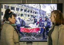 Ludmila Karpenko y Natalya Yosypenko se miran ante 'Asedio a Mariupol' (World Press Photo 2023) de Evgeniy Maloletka.