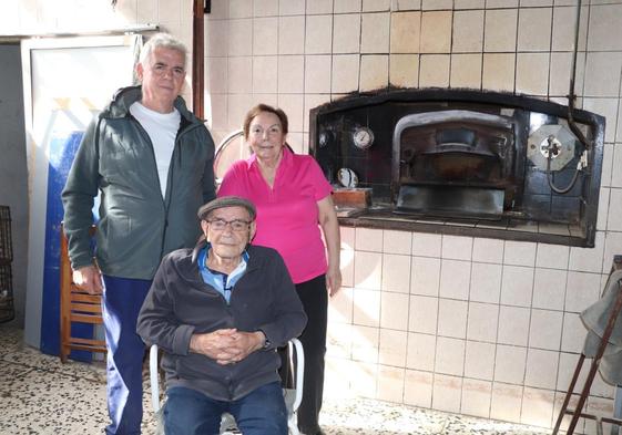 José Antonio Abad (hijo) y su tía Mari Carmen, junto a José Antonio Abad (padre) en el horno de leña característico del sabor del pan y de las magdalenas de la Panadería La Felisa.