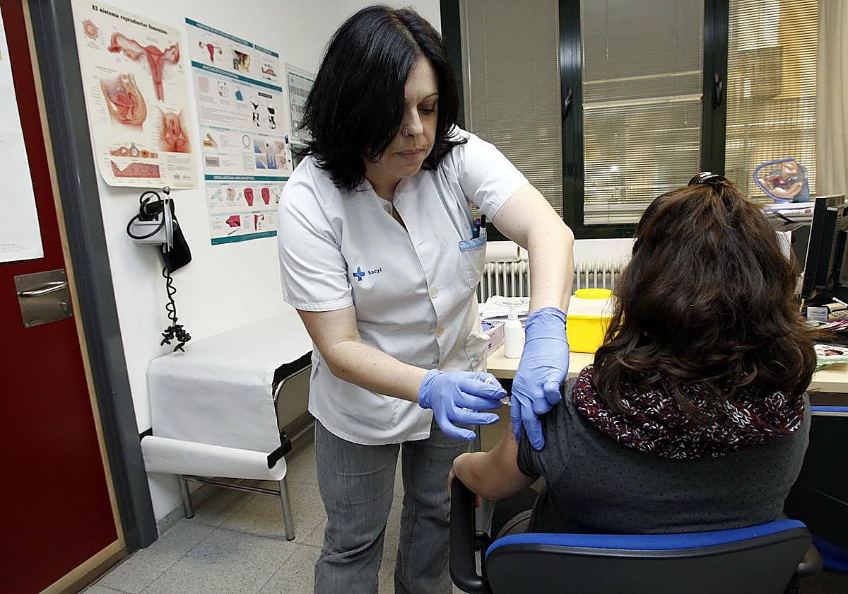 Una enfermera vacuna a una mujer embarazada en un centro de salud.