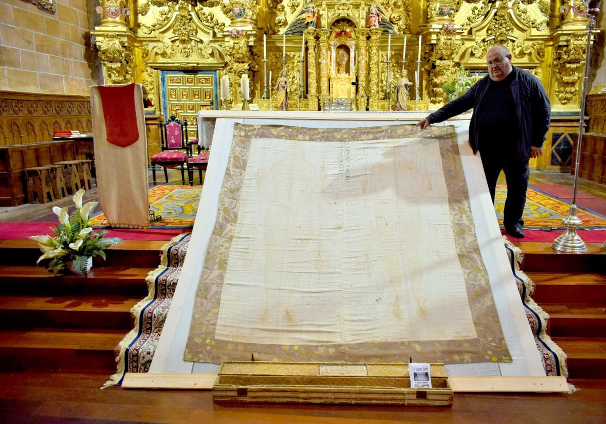 El párroco del Camero Viejo, Antonio Arnedo, muestra la réplica de la Sábana Santa de Laguna.