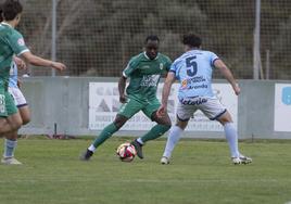 Aitor Lorá, con el balón, busca zafarse de la defensa local.