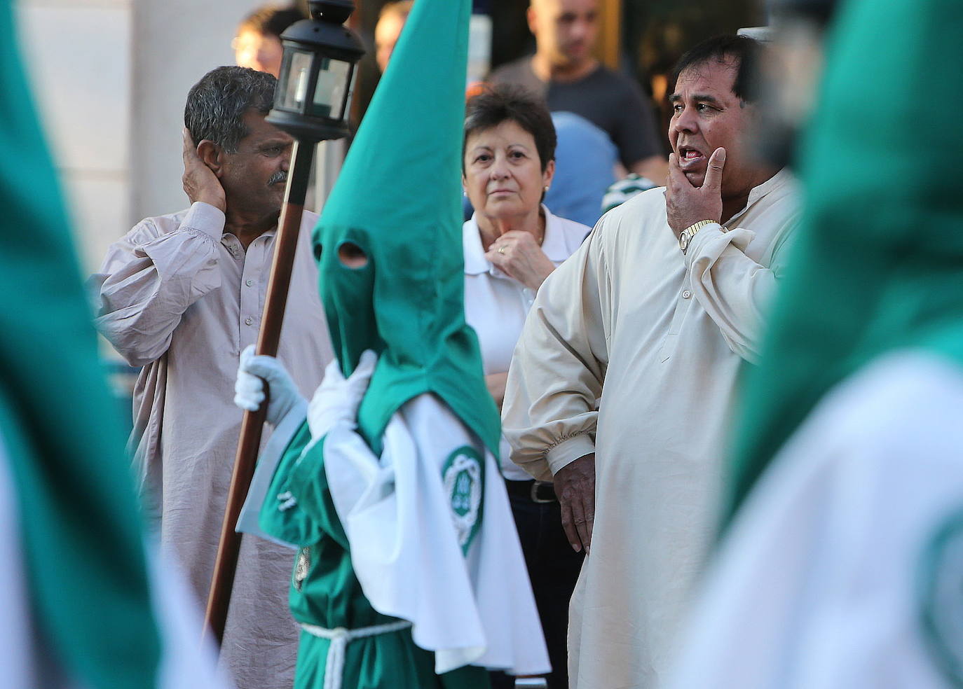 Dos inmigrantes observan con gesto de extrañeza un paso procesional en Logroño