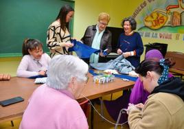 Isabel Benito, directora de Cáritas, la segunda por la derecha en el grupo de voluntarias que está de pie en la imagen, en el taller de costura.