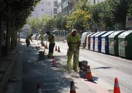 Cuatro operarios desmantelan el carril de avenida de Portugal.