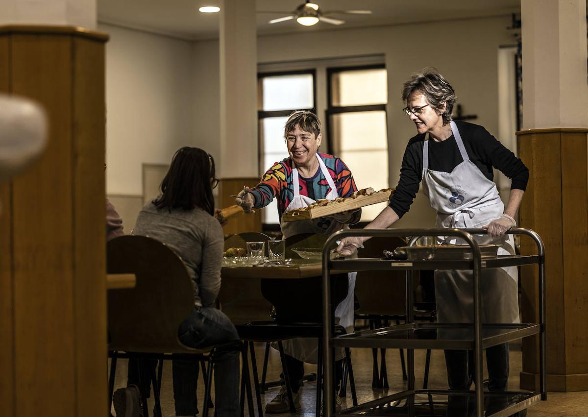 Imagen secundaria 1 - Empleados y voluntarios de la Cocina Económica desarrollan su labor.