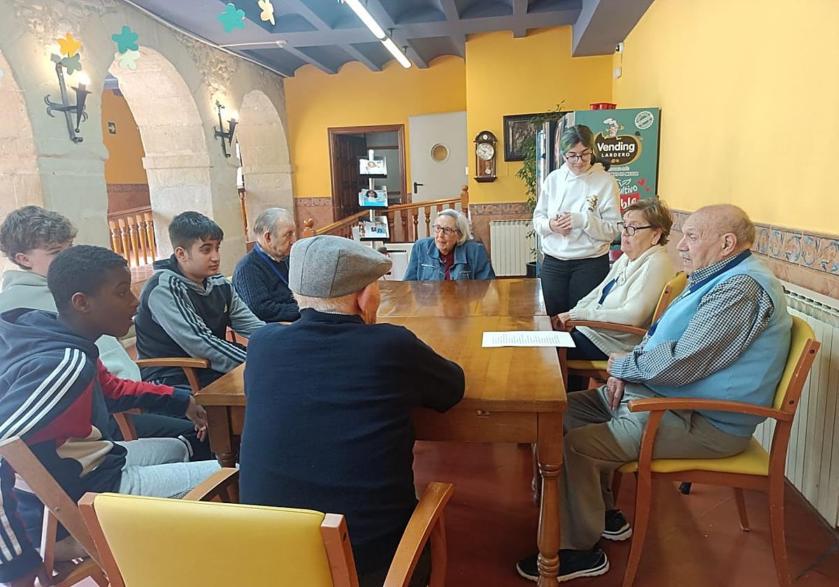 Tres jóvenes escuchaban atentos el relato de varias personas mayores.