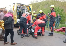 Bomberos y personal sanitario introducen al herido en la ambulancia.