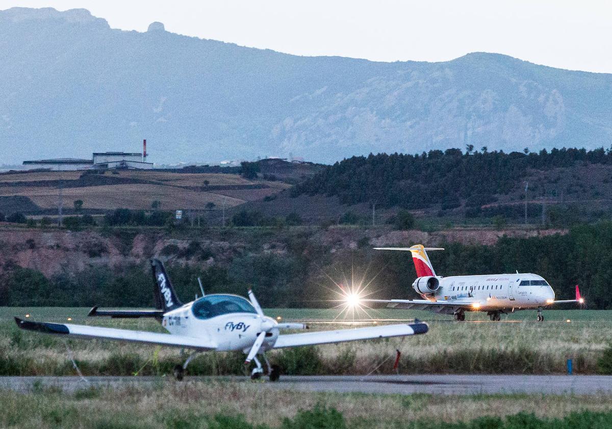 El avión de Madrid, a la derecha, toma tierra mientras en primer plano hace pruebas una aeronave de la escuela de pilotos.