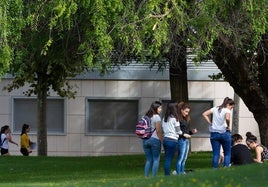 Un grupo de jóvenes conversan fuera de un aula.