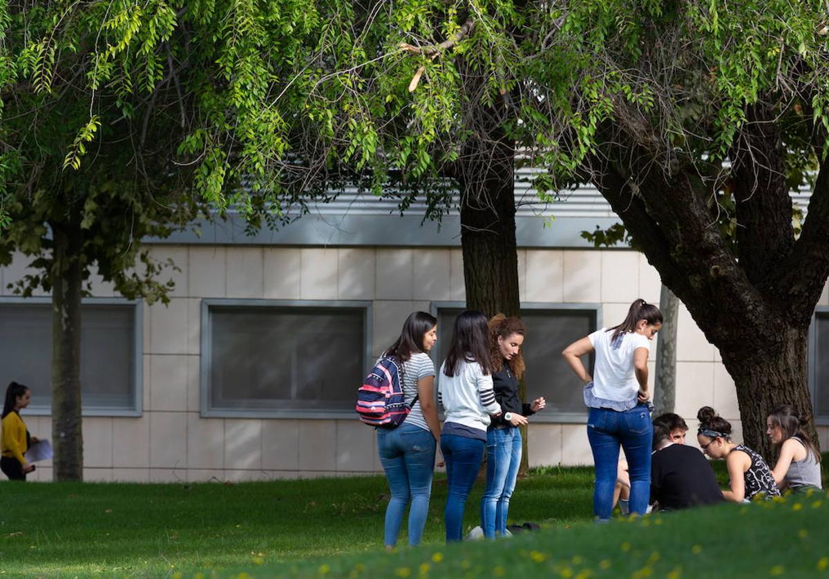 Un grupo de jóvenes conversan fuera de un aula.