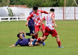 Juanjo, del Varea, intenta llevarse el balón durante el encuentro que arlequinados y el Anguiano empataron 1-1.