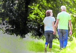 Una pareja de personas mayores da un paseo.