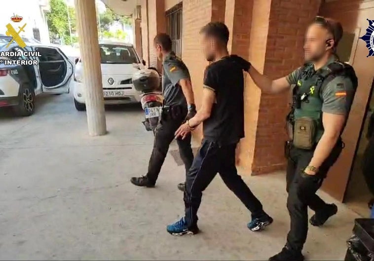 Los agentes, con uno de los detenidos.