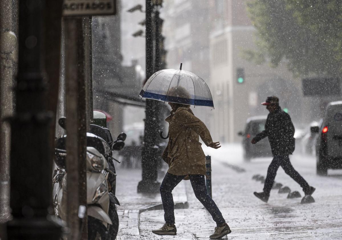 Una ciudadana se protege de una de las tormentas registradas el pasado mes de mayo.