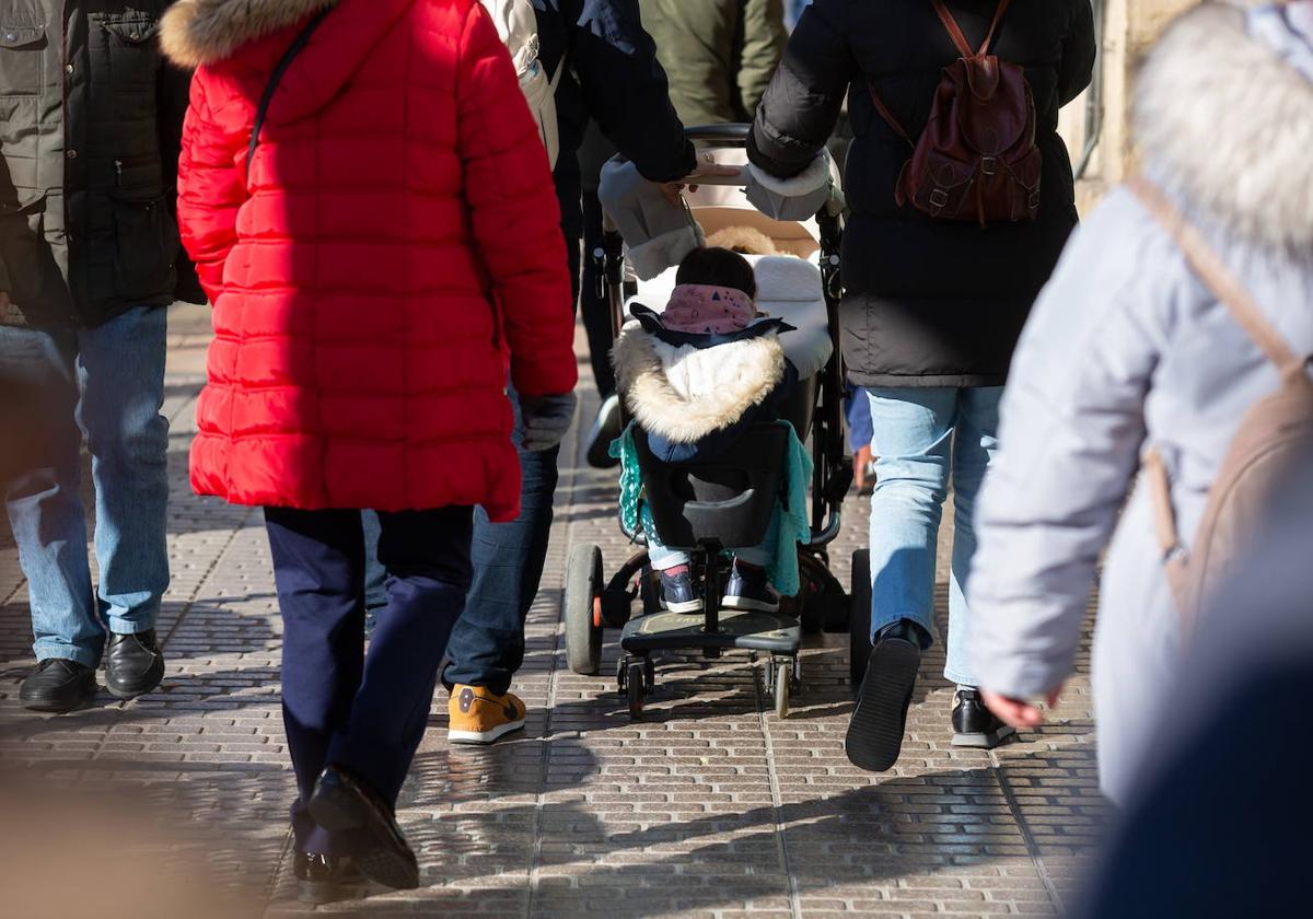 Una familia empuja el carro en el que va su bebé.