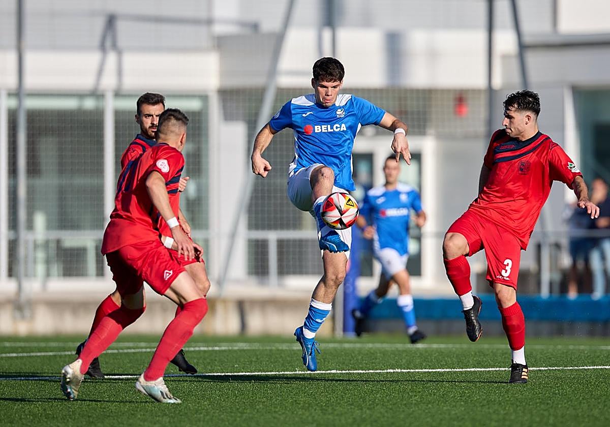 Los jugadores del Anguiano presionan al rival para hacerse con la posesión en El Pinar del Ardoi.