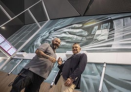 Carlos Corres con Conrado Escobar, con el mural de la estación de fondo