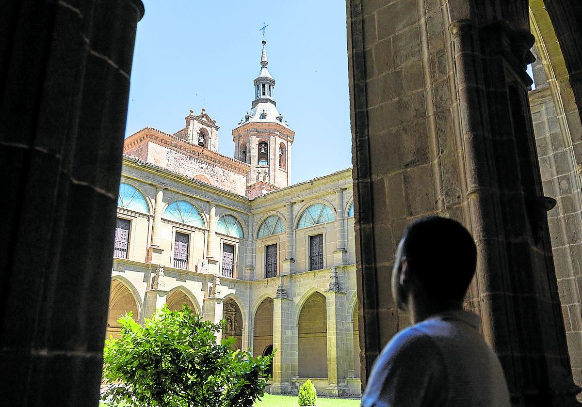 Un turista observa la torre desde el interior del claustro, coronada por una campana llamada 'La Bomba' .