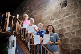 Judy, Laurie, Montse y Michela posan con el cartel de bienvenida en el Hospital de Peregrinos San Juan Bautista de Grañón.