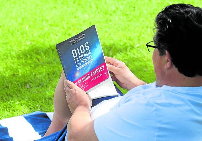 Angelo leyendo su libro 'Dios, la ciencia y las pruebas' a la sombra de un árbol en Aqualar.