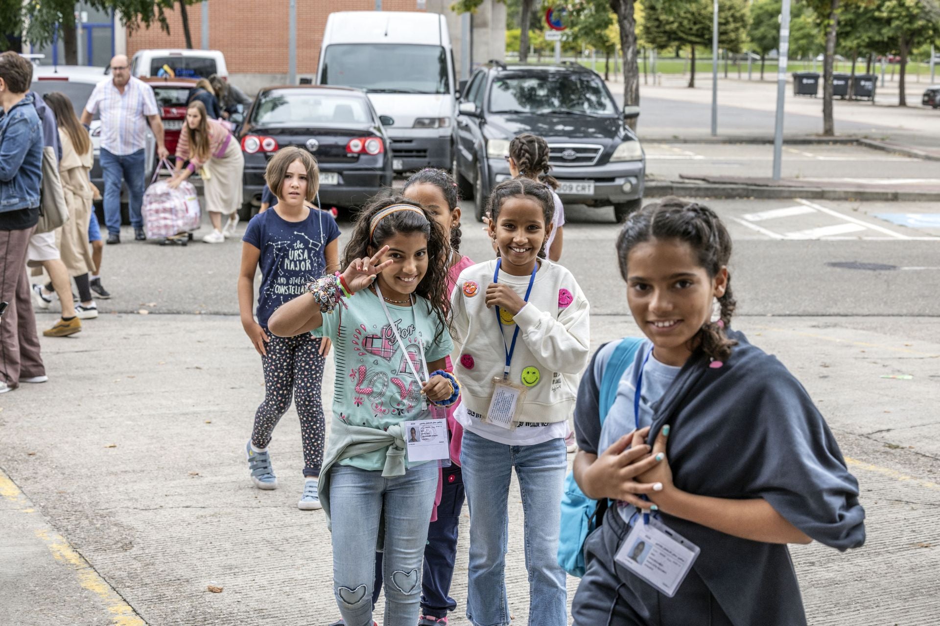 Un grupo de niñas juega mientras llegan las últimas familias y acomodan los equipajes