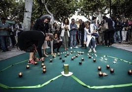 Público asistente al acto celebrado ayer en El Espolón coloca velas en recuerdo a los riojanos que se han quitado la vida.