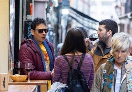 Unos jóvenes toman vino en la calle Laurel.