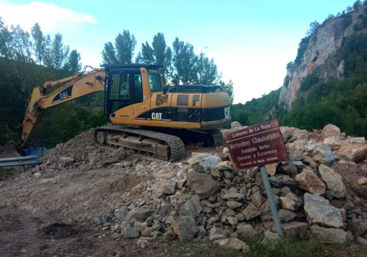 Una excavadora de las obras de la LR-454 sobre el vertido de tierra y piedras en el vertedero clausurado de Pradillo.