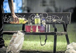 Un joven prepara las bebidas en un banco del parque del Ebro durante un botellón.