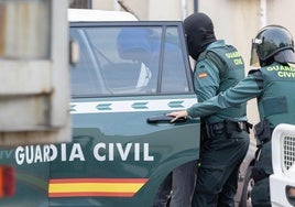 Los agentes se llevan a uno de los detenidos en la calle Ebro.