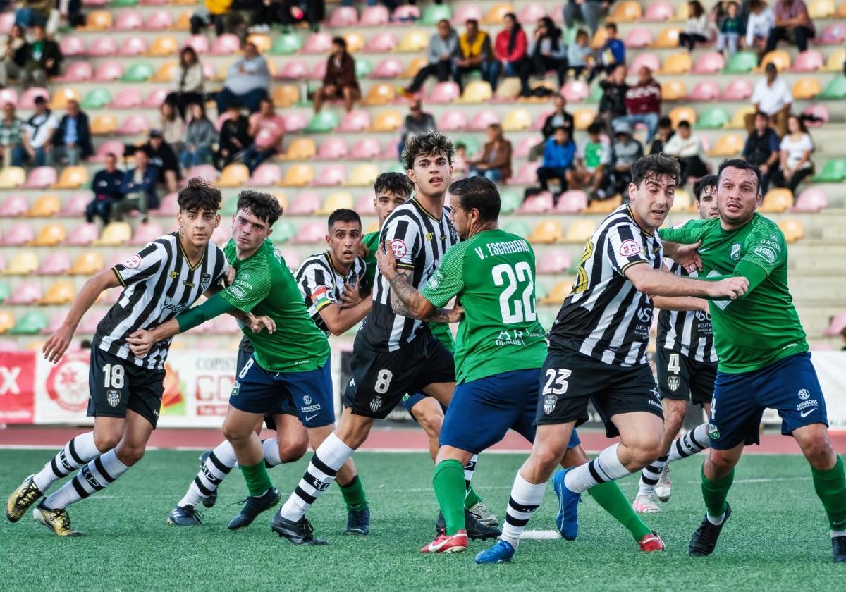 Jugadores del Haro tratan de avanzar ante una barrera del Berceo buscando el balón.