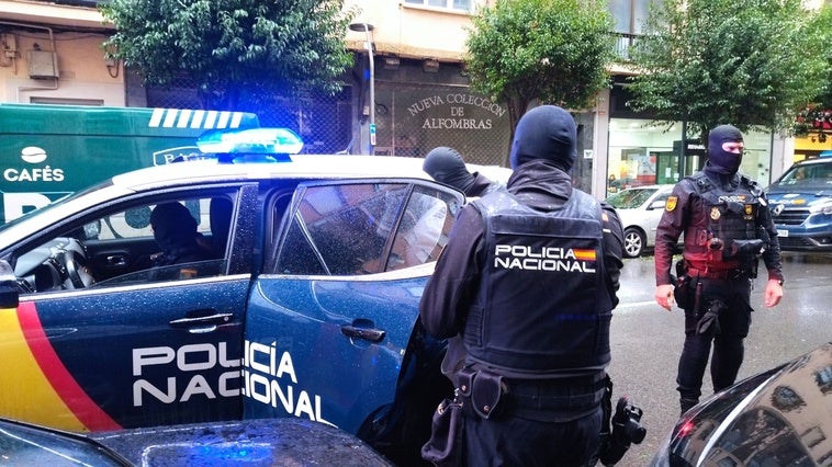 Los agentes de la Policía Nacional se llevan a uno de los detenidos.