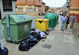 Bolsas de basura alrededor de un contenedor de basura en la calle Anastasio Mateo de Villamediana de Iregua.