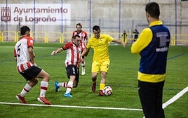 El local Vitorica conduce el balón ante dos jugadores del Autol.