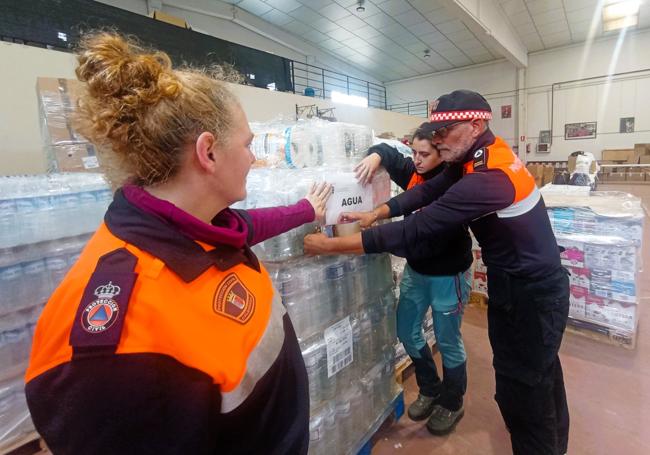 Miembros de Protección Civil preparando un palé de agua para Valencia esta semana, en la nave de la Vera Cruz.