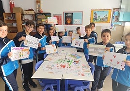 Alumnos del colegio Paula Montal Escolapias posan con los dibujos y mensajes de ánimo que han elaborado para los niños afectados por la DANA.