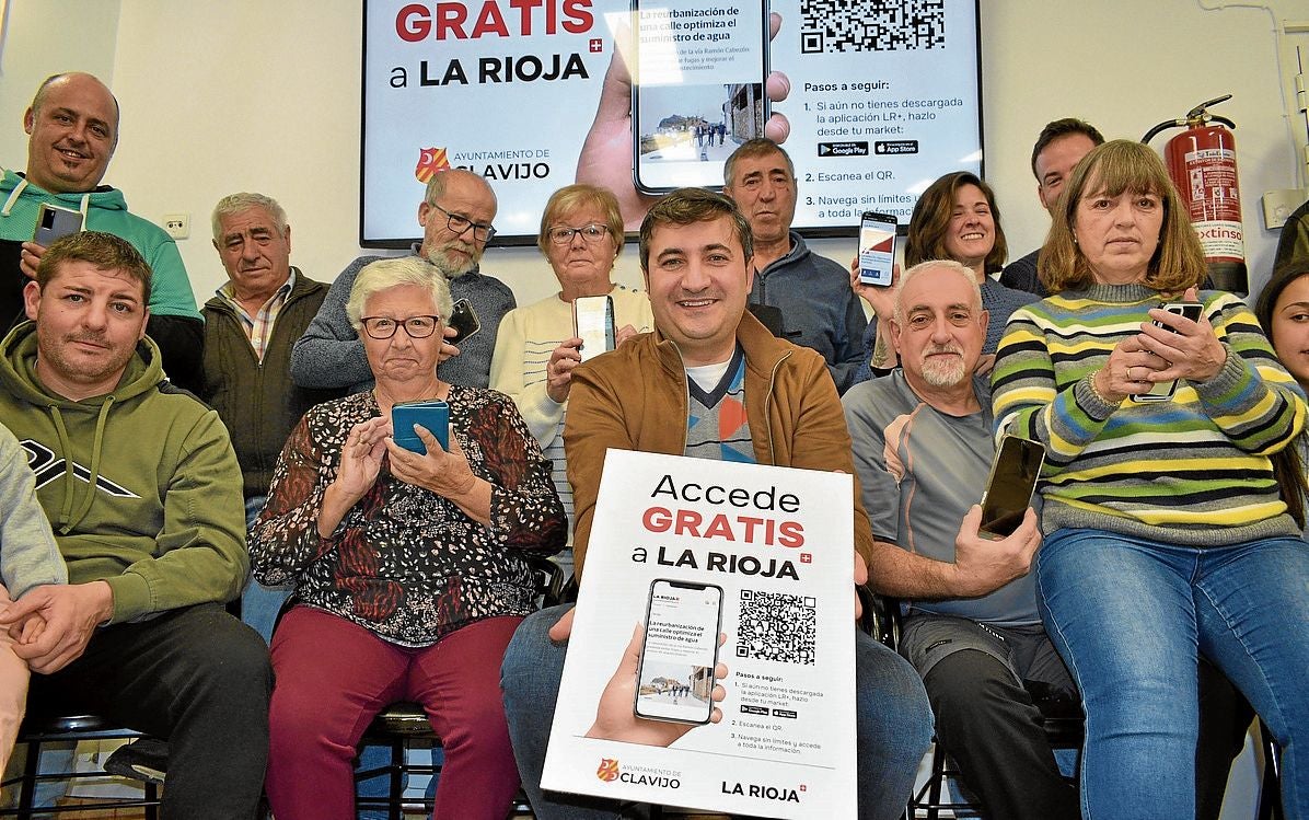 El alcalde de Clavijo, Pedro Muro, y varios vecinos muestran el cartel de la nueva promoción del periódico.